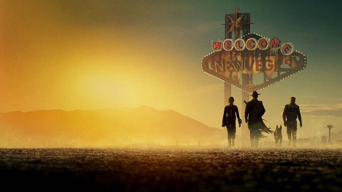 Lucy, The Ghoul, and a companion walk toward a weathered Welcome to New Vegas sign at sunset