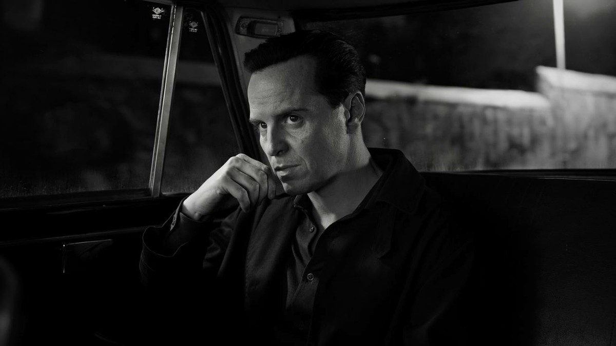 Andrew Scott as Tom Ripley, watching from the back seat of a car in monochrome
